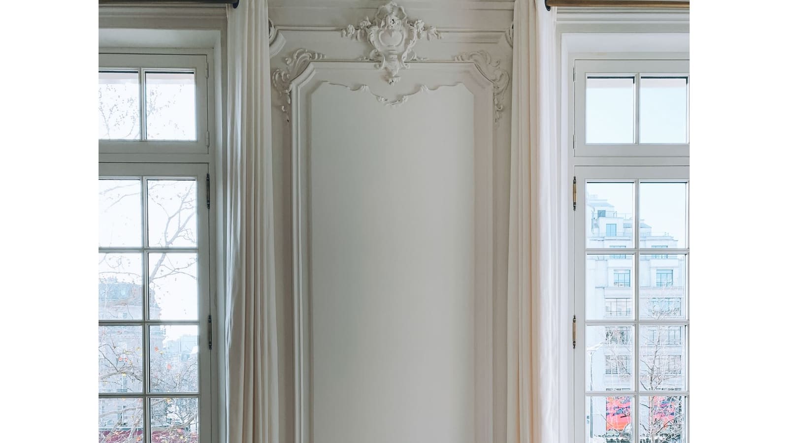 Pre-war room with tall windows, ornate mouldings and an armchair in the light