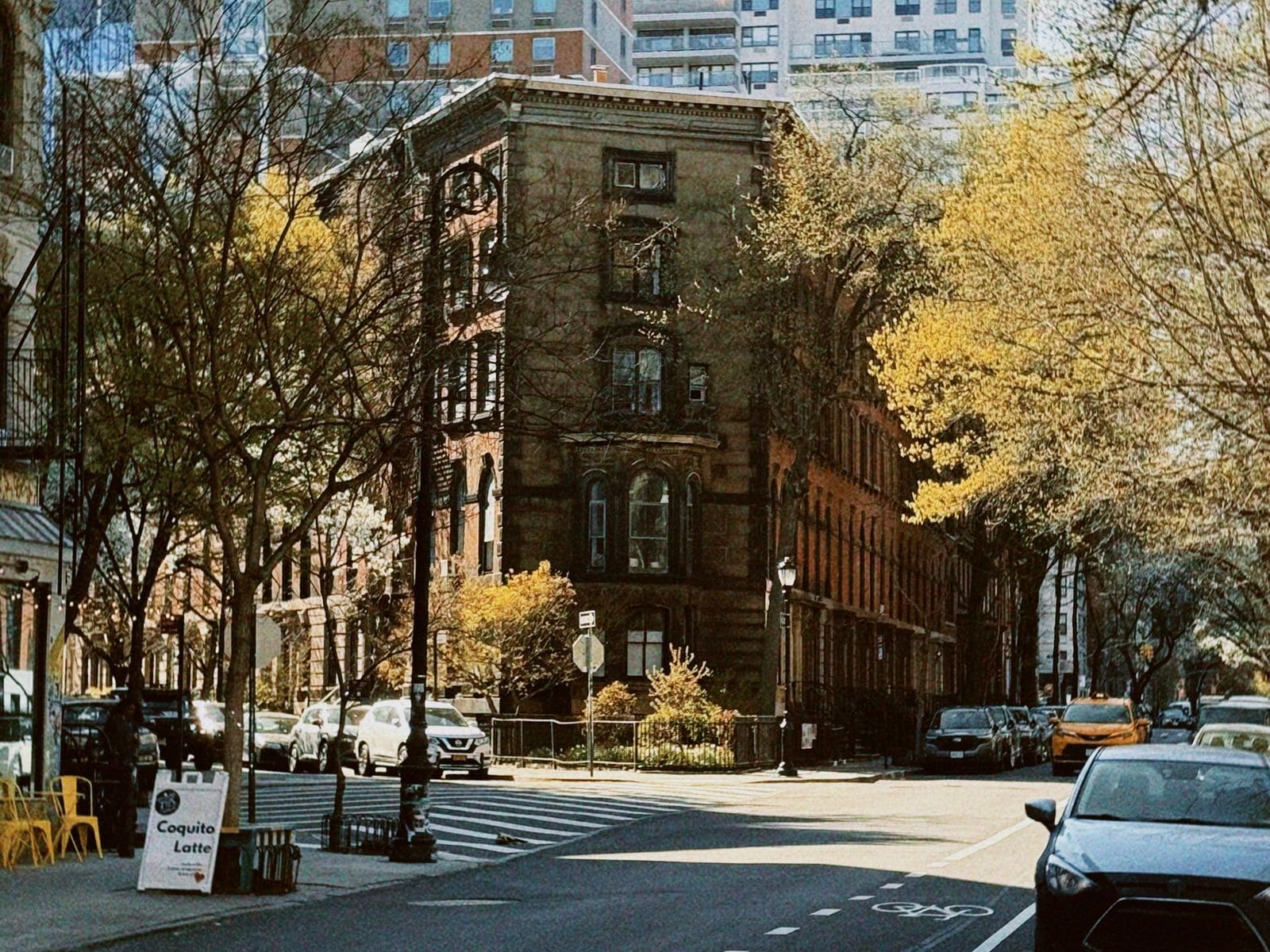 Sunny West Village street with historic townhouses